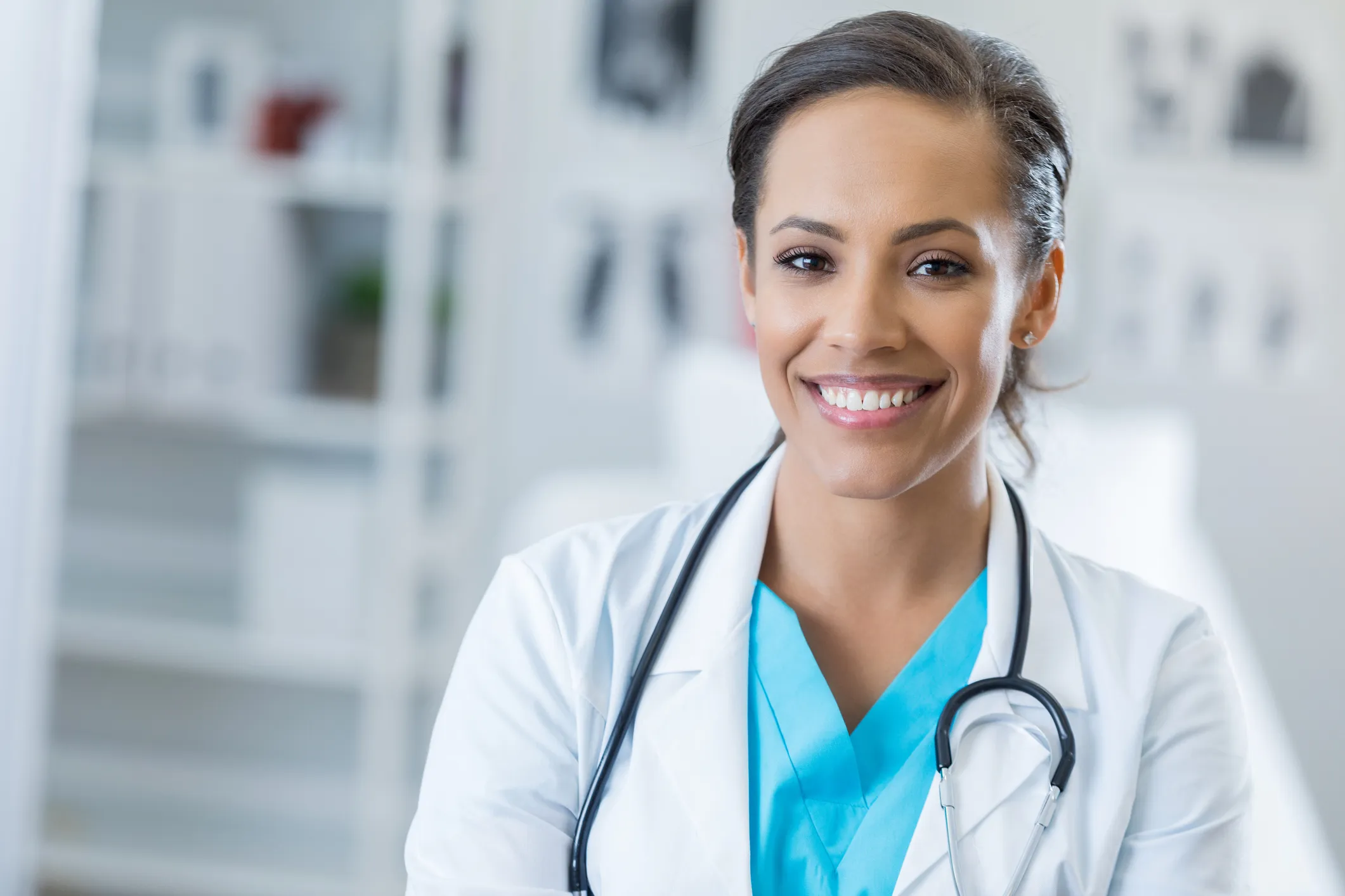 Portrait of confident female healthcare professional Pretty mid adult African American surgeon smiles cheerfully at the camera. She is wearing a stethoscope and lab coat.